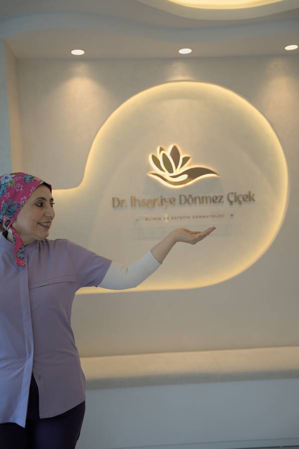 Dr Flower  posing in front of the clinic logo